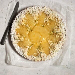 A tart with pears, flaked almonds, pistachios and powdered sugar