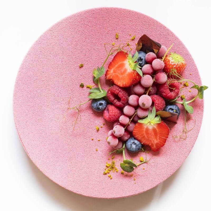 Eine vegane Himbeermoussetorte mit Beerendekor