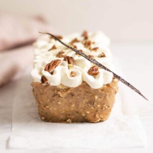 A carrot cake with white vanilla cream and chopped pecans