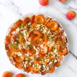 An apricot tart seen from above with almond flakes