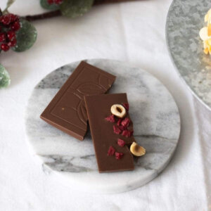 Eine Tafel Schokolade aus Milchschokolade mit Himbeercrispies und Haselnüssen