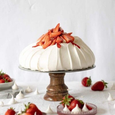 A Pavlova cake with strawberries on a cake stand