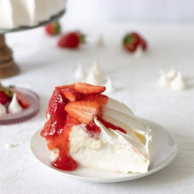 A piece of Pavlova cake and strawberries on a plate