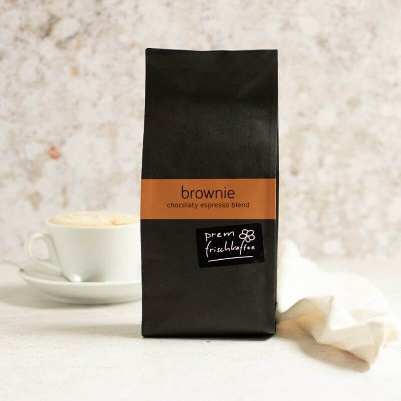 A coffee pack of prem fresh coffee brownie blend and a coffee cup