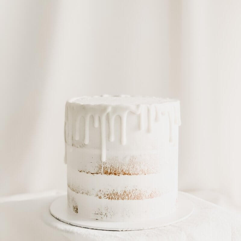 a single tier birthday cake with white drip