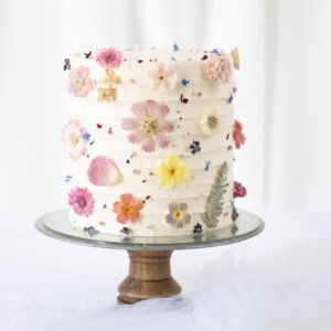 Eine Torte mit Creme und verzuckerten Blüten dekoriert auf Etagere