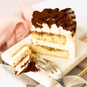 A slice of tiramisu cake. The layers of cream and cake are visible.